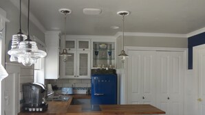 Une cuisine avec un îlot central, une machine à café et un réfrigérateur bleu.