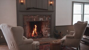 A living room with a fireplace, two armchairs, and a coffee table. - Stonehill's Farmhouse (Accord)
