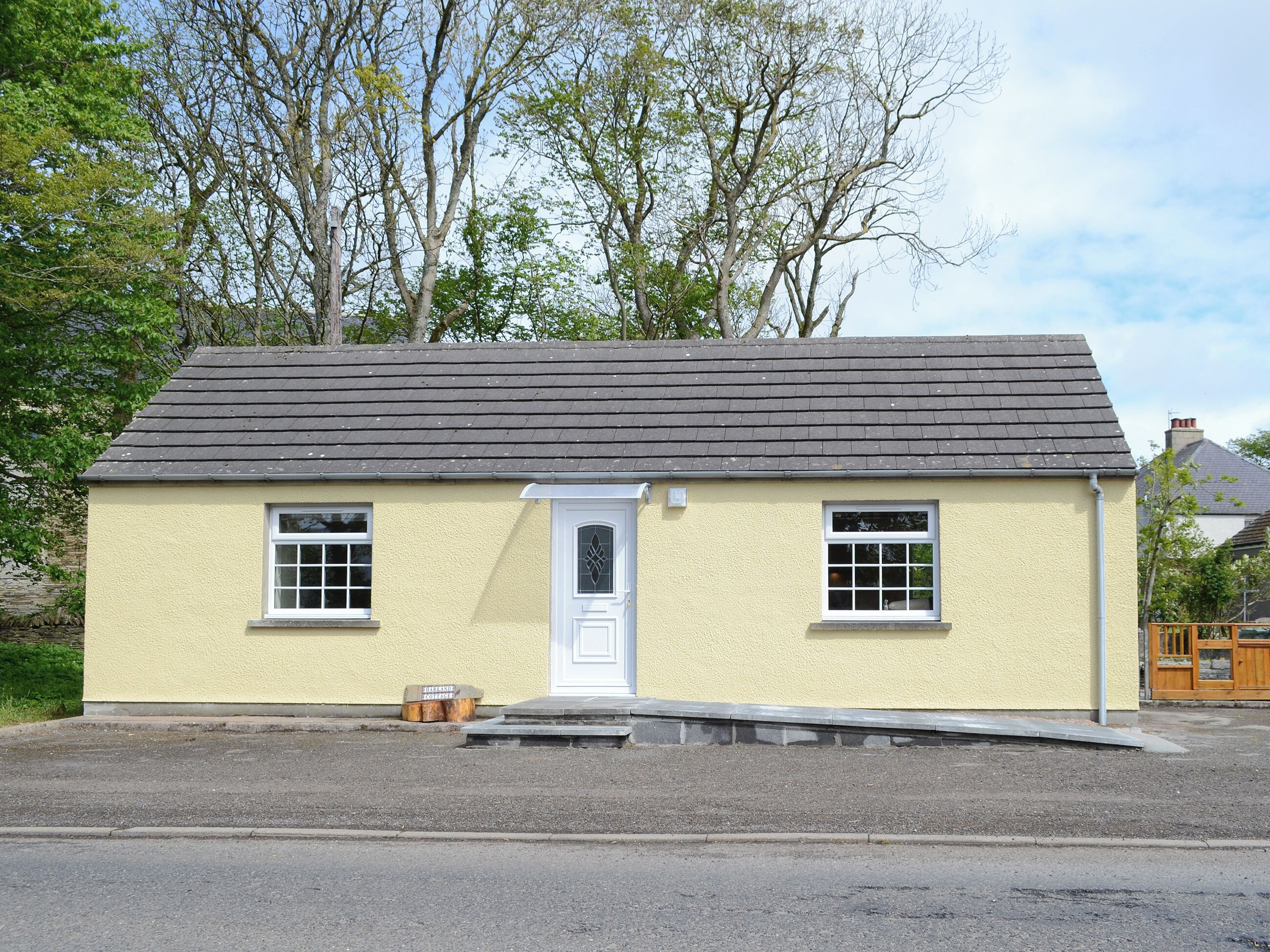 A small, single-story building with a gabled roof and a white door.