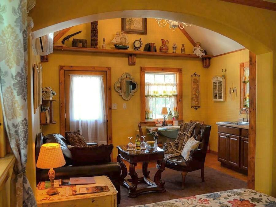 Een gezellige woonkamer met een open haard, een eethoek en een keuken.