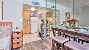 Une cuisine moderne avec des meubles en bois, un four à micro-ondes et un coin repas avec une table mise pour deux personnes.