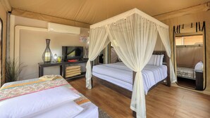 A bedroom with a canopy bed, a television, and a desk with a lamp and books. - Dubbo Rhino Lodge (Dubbo)