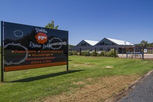 Señal de Dubbo Rhino Lodge que anuncia eventos, conferencias, bodas y alojamiento, con sitio web y número de teléfono.