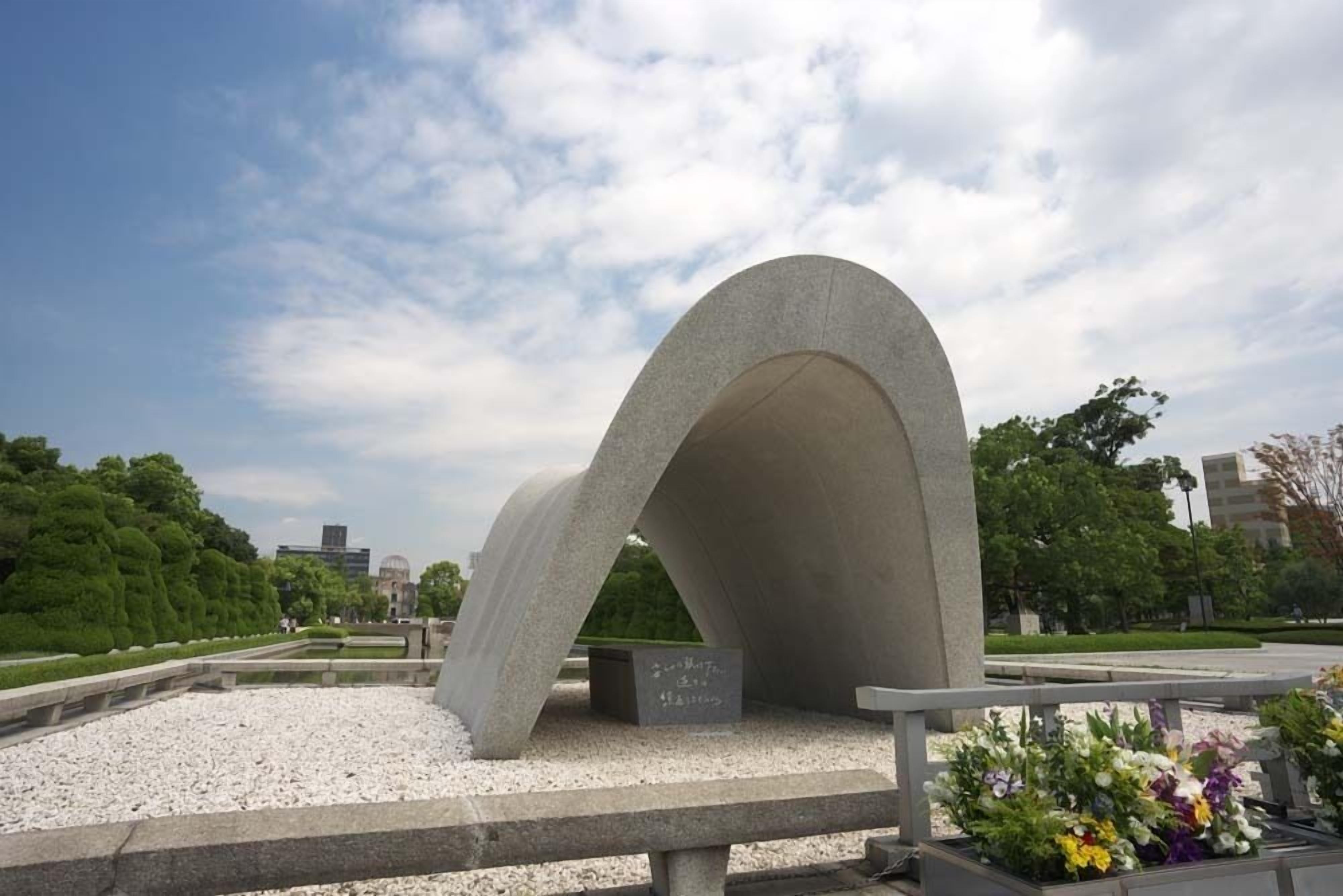 A concrete structure with a curved top, surrounded by gravel and greenery.