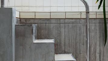 A set of metal steps leading up to a tiled wall.