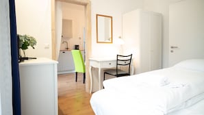 Een hotelkamer met een bed, een bureau, een stoel en een kledingkast.