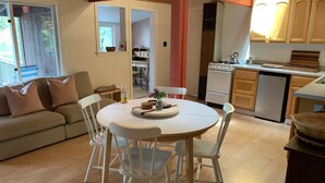 Una cocina acogedora con comedor, armarios de madera y una estufa blanca.