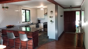 A modern kitchen with a central island, bar stools, and a dining area. - Relaxing big sky views early booking discounts for Summer! (Highlands)