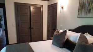 A hotel room with a large bed, two doors, and a wall-mounted light fixture. - Relaxing big sky views early booking discounts for Summer! (Highlands)