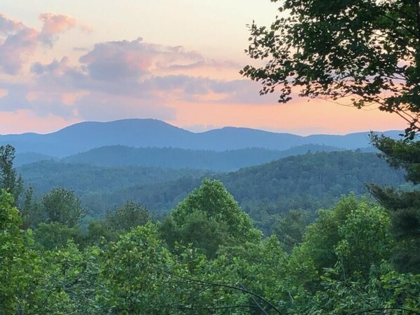 A mountainous landscape with dense forest in the foreground and hills in the background. - Relaxing big sky views early booking discounts for Summer! (Highlands)