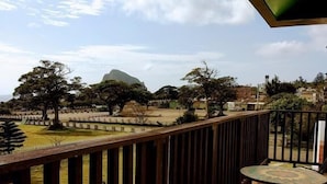 A balcony with a view of a mountainous landscape, a tiled floor, and a table with chairs. - Summer Homestay (Hengchun)