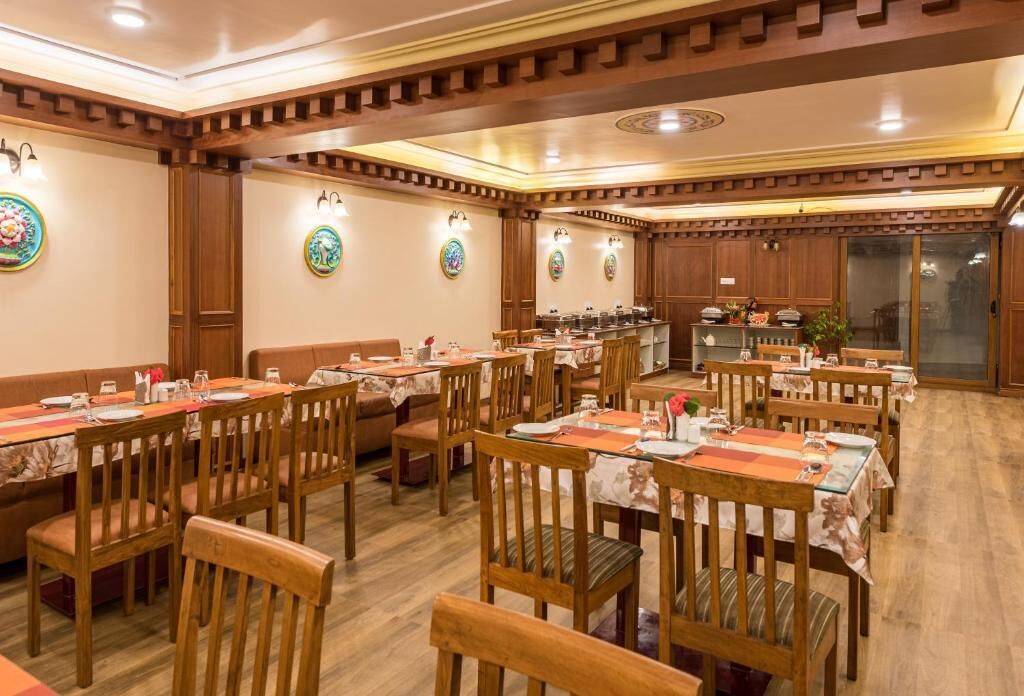 Un comedor con varias mesas y sillas, paneles de madera y adornos en las paredes.