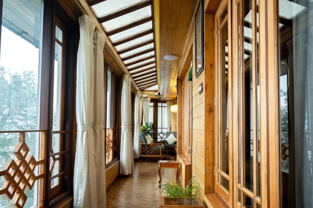 A wooden corridor with large windows and a wooden ceiling.