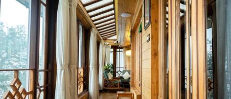 A wooden corridor with large windows and a wooden ceiling.