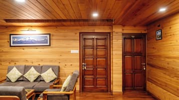 A wooden interior with a sofa, two doors, and a framed picture on the wall.