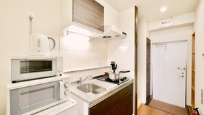 Una cocina compacta con microondas, tostadora y estufa.