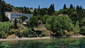 Una zona costera con aguas cristalinas, una playa y edificios al fondo.