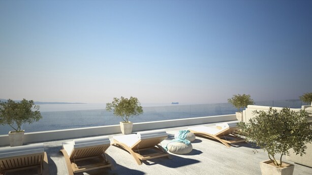 Una terraza en la azotea con sillones de descanso, una mesita y plantas en macetas.