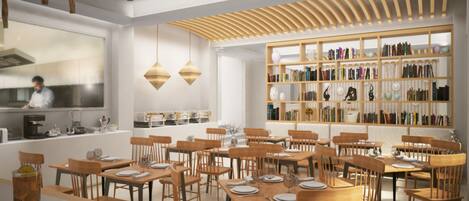 A modern restaurant with wooden tables and chairs, a kitchen area, and a bookshelf filled with books.