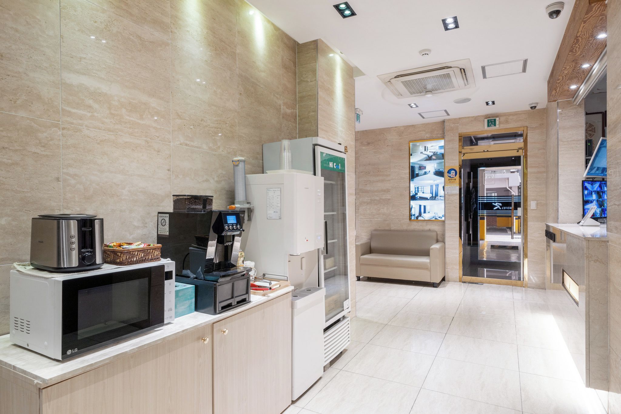 Eine moderne Hotelküche mit Mikrowelle, Kaffeemaschine und Kühlschrank.