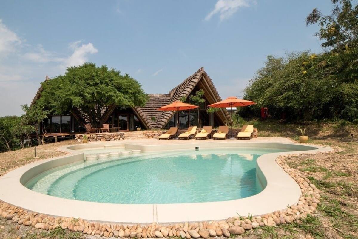 A pool area with lounge chairs and umbrellas, surrounded by a stone border.