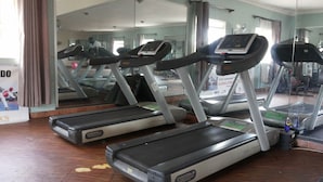 A gym with treadmills, mirrors, and exercise equipment. - Pauline Hotel (Lira)