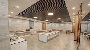 A modern kitchen with marble countertops, a central island, and a wooden ceiling design. - Zhongdao Hotel (Guangzhou Shacun Metro Station) (Guangzhou)