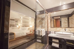 A modern bathroom with a glass shower enclosure, a large mirror, and a white sink. - Zhongdao Hotel (Guangzhou Shacun Metro Station) (Guangzhou)