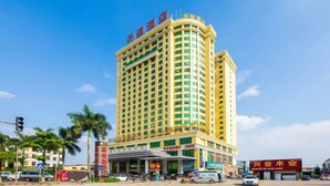 A multi-story hotel with a curved facade, multiple balconies, and a prominent entrance with a covered area. - Zhongdao Hotel (Guangzhou Shacun Metro Station) (Guangzhou)