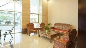 A lobby with a wooden sofa, chairs, a coffee table, and a large window offering a view of the outside. - Zhongdao Hotel (Guangzhou Shacun Metro Station) (Guangzhou)