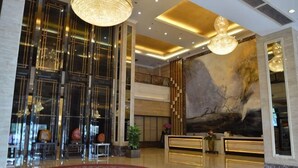 A lobby with a reception desk, large windows, a chandelier, and a mural. - Zhongdao Hotel (Guangzhou Shacun Metro Station) (Guangzhou)
