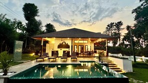 A house with a swimming pool, outdoor seating, and a covered patio area. - Tranquil Resort - BluSalzz Collection, Wayanad (Sulthan Bathery)