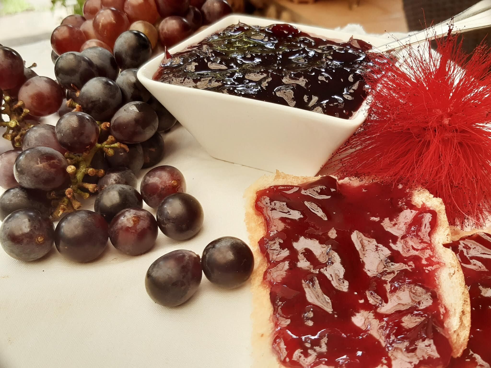 A plate with a variety of fruits and a small bowl of jam.