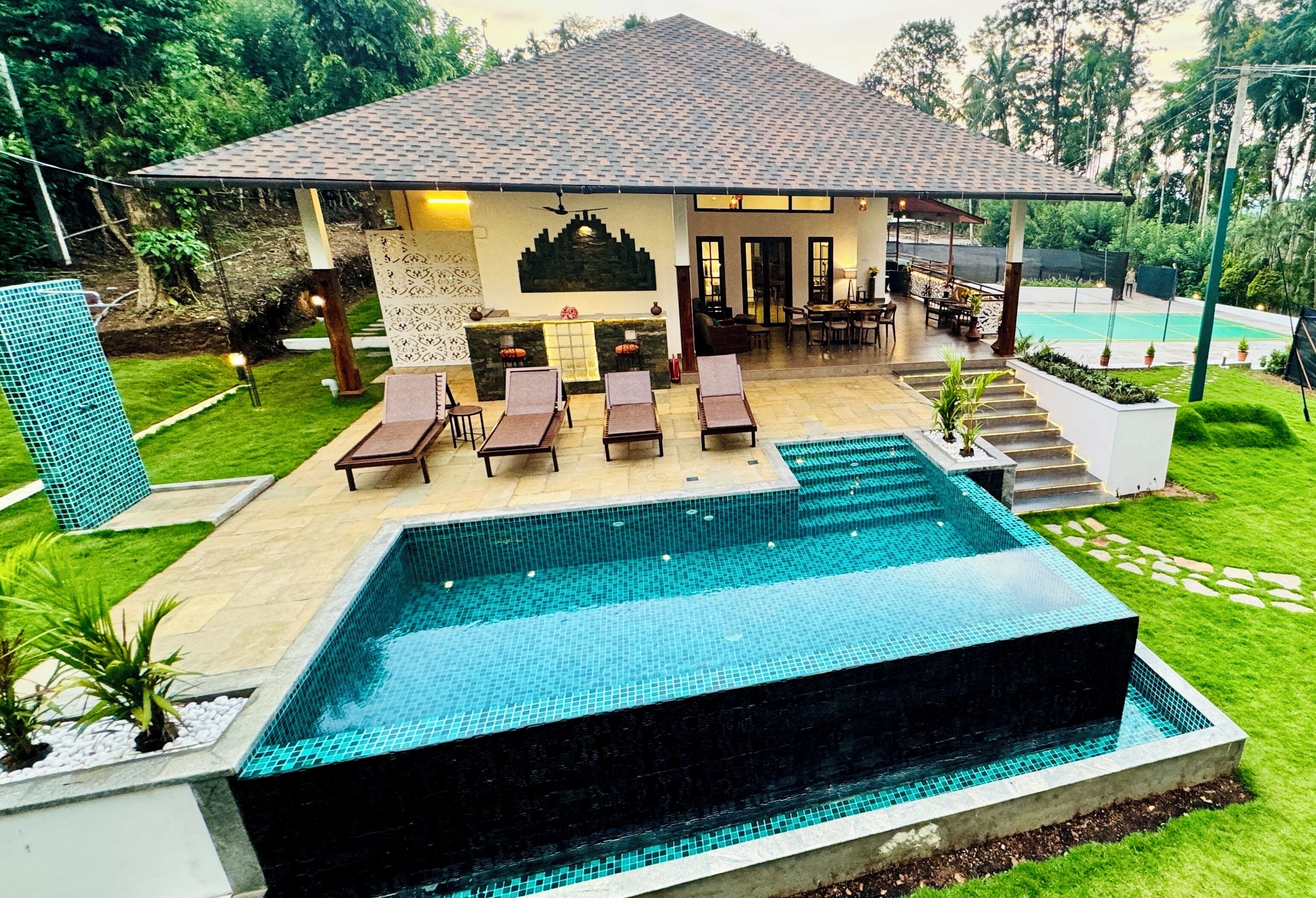 Una casa moderna con piscina, mobiliario exterior y un jardín bien cuidado.