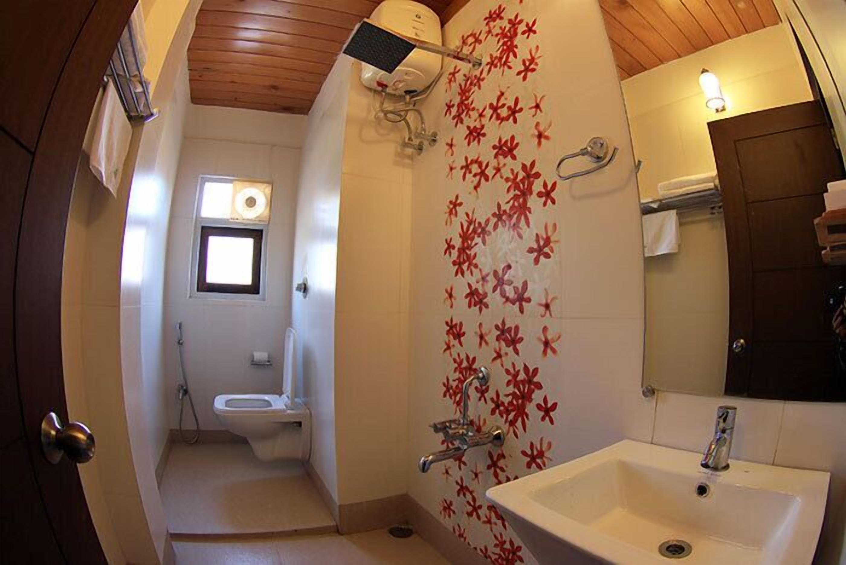Un baño con inodoro, lavamanos y ducha.