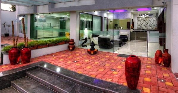 Zona de recepción con mostrador, asientos y pared de vidrio.