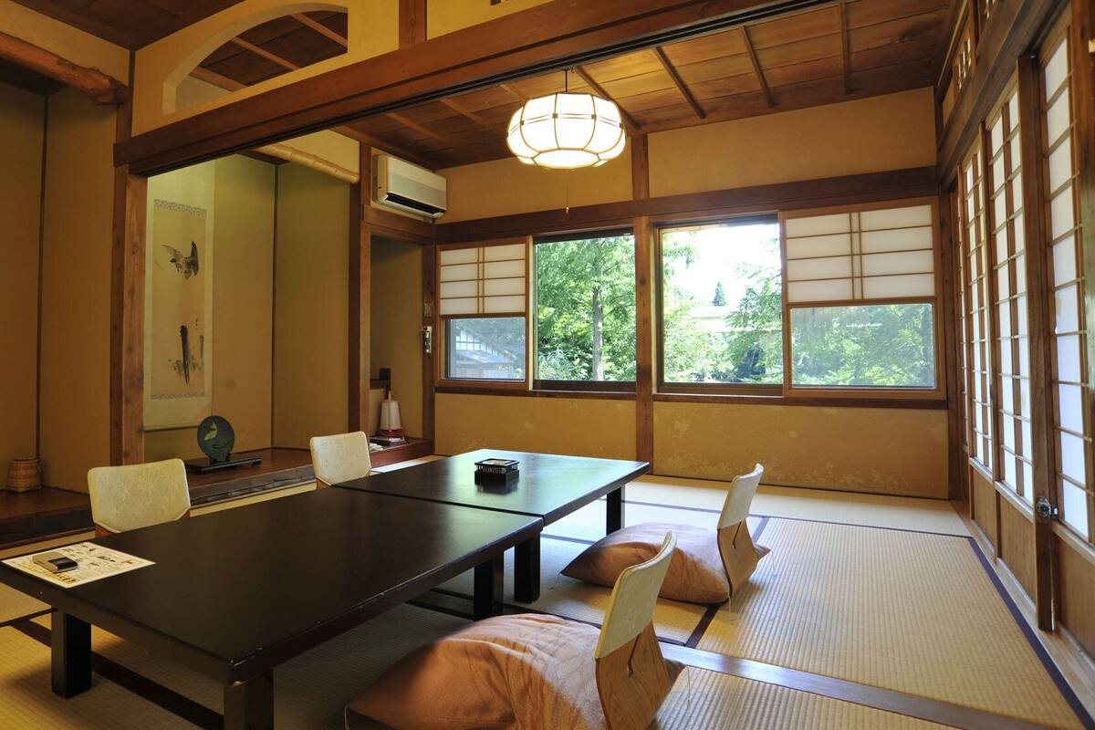 A traditional Japanese room with tatami flooring, a low table, and sliding doors.
