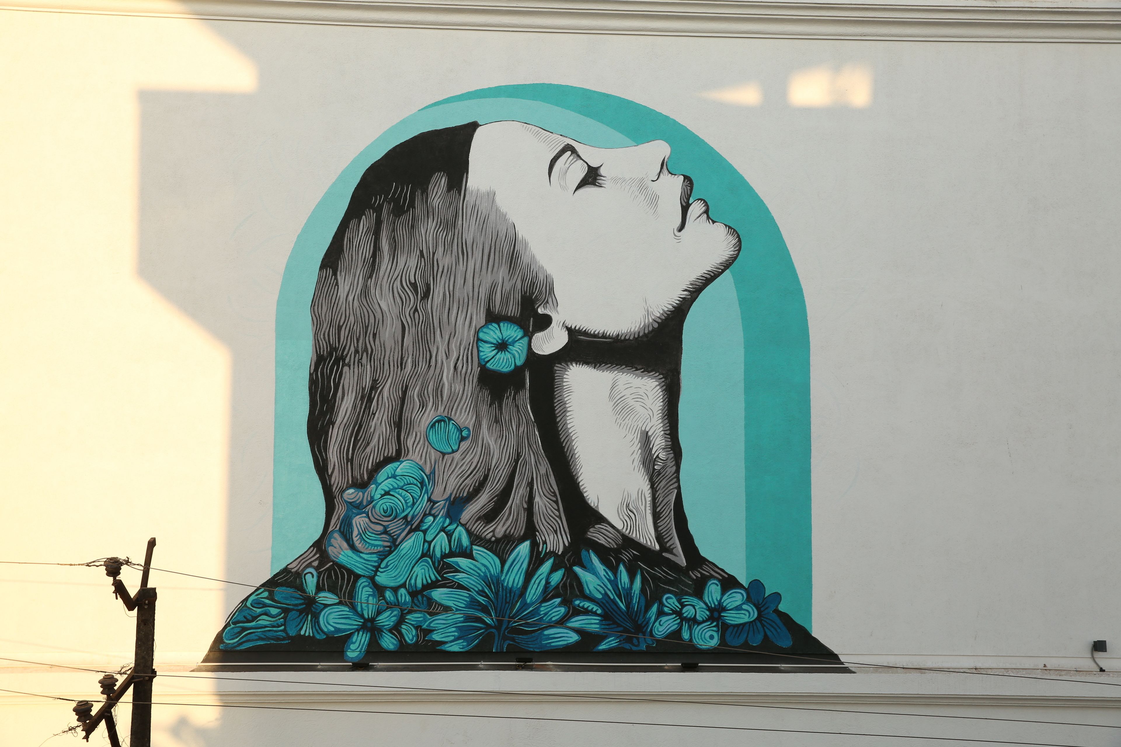 Une fresque murale représentant une femme avec une fleur.
