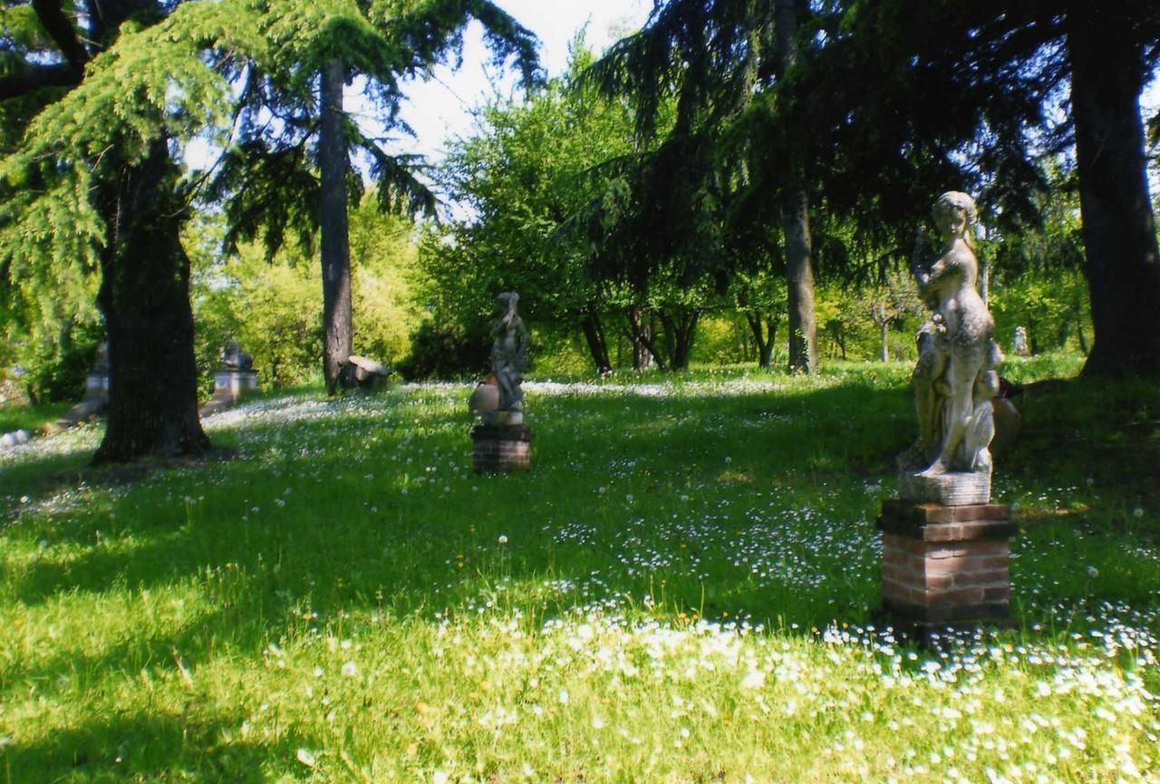 Un parque con estatuas y árboles.
