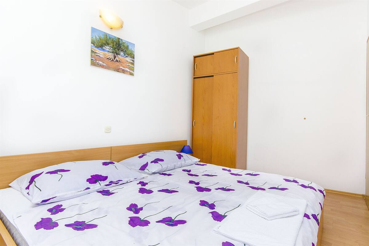 Una camera da letto con un letto, un armadio e un quadro appeso al muro.
