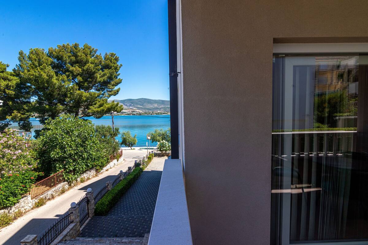A balcony with a view of a body of water and distant hills.