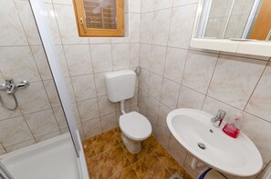 Ein Badezimmer mit Toilette, Waschbecken und Dusche.