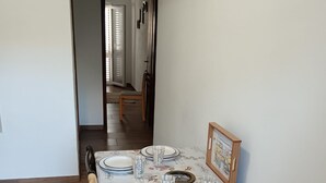 A dining area with a table set for four, chairs, and a bench. - Apartment Milan (Vrboska)