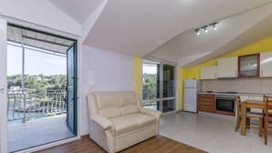 A modern apartment with a balcony, a kitchen, and a dining area. - Apartment Ivo (Basina)