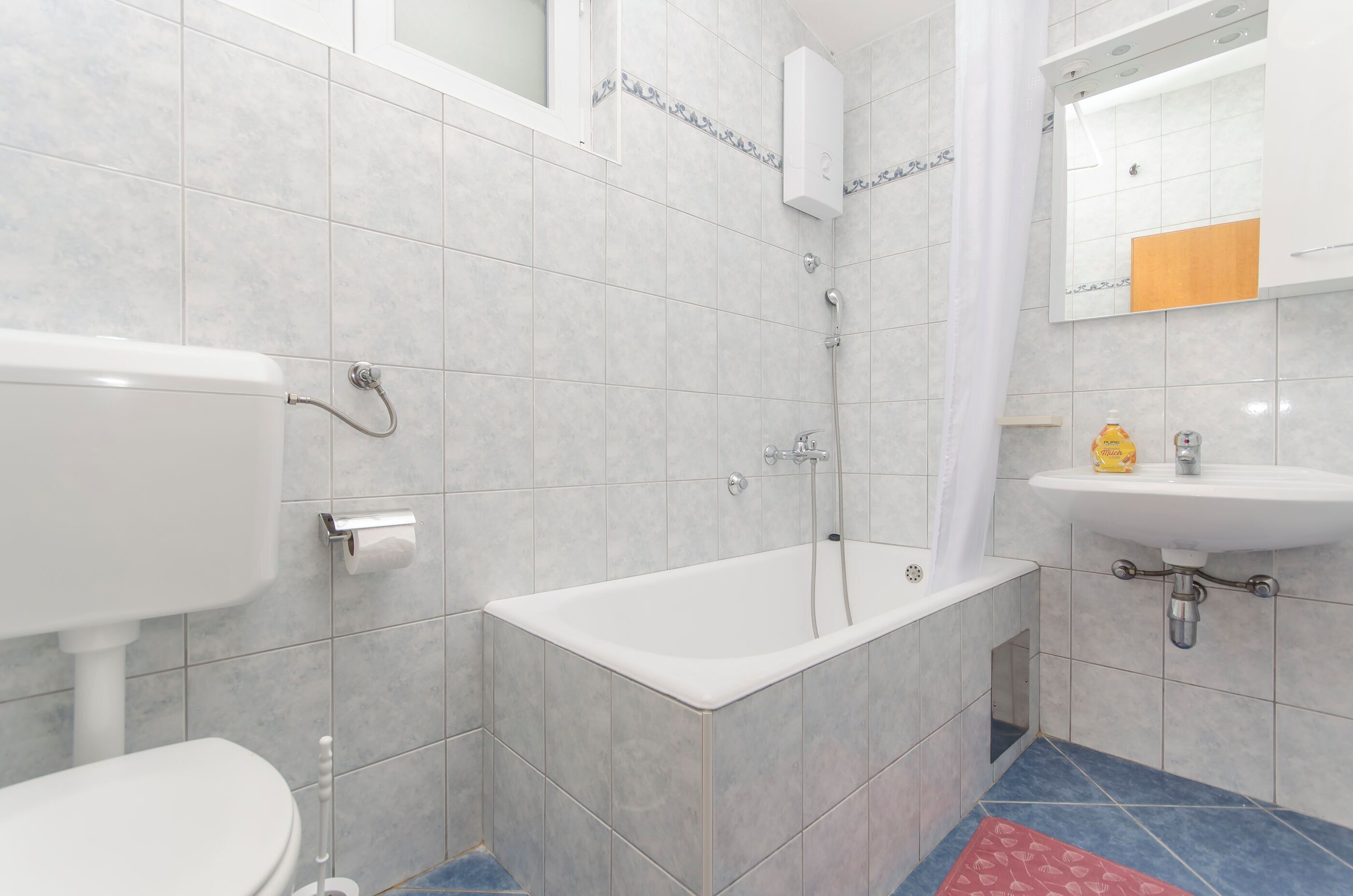 A bathroom with a toilet, bathtub, and sink.
