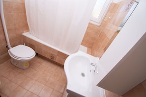 A bathroom with a toilet, bathtub, and sink. - Apartment Brko (Primosten)