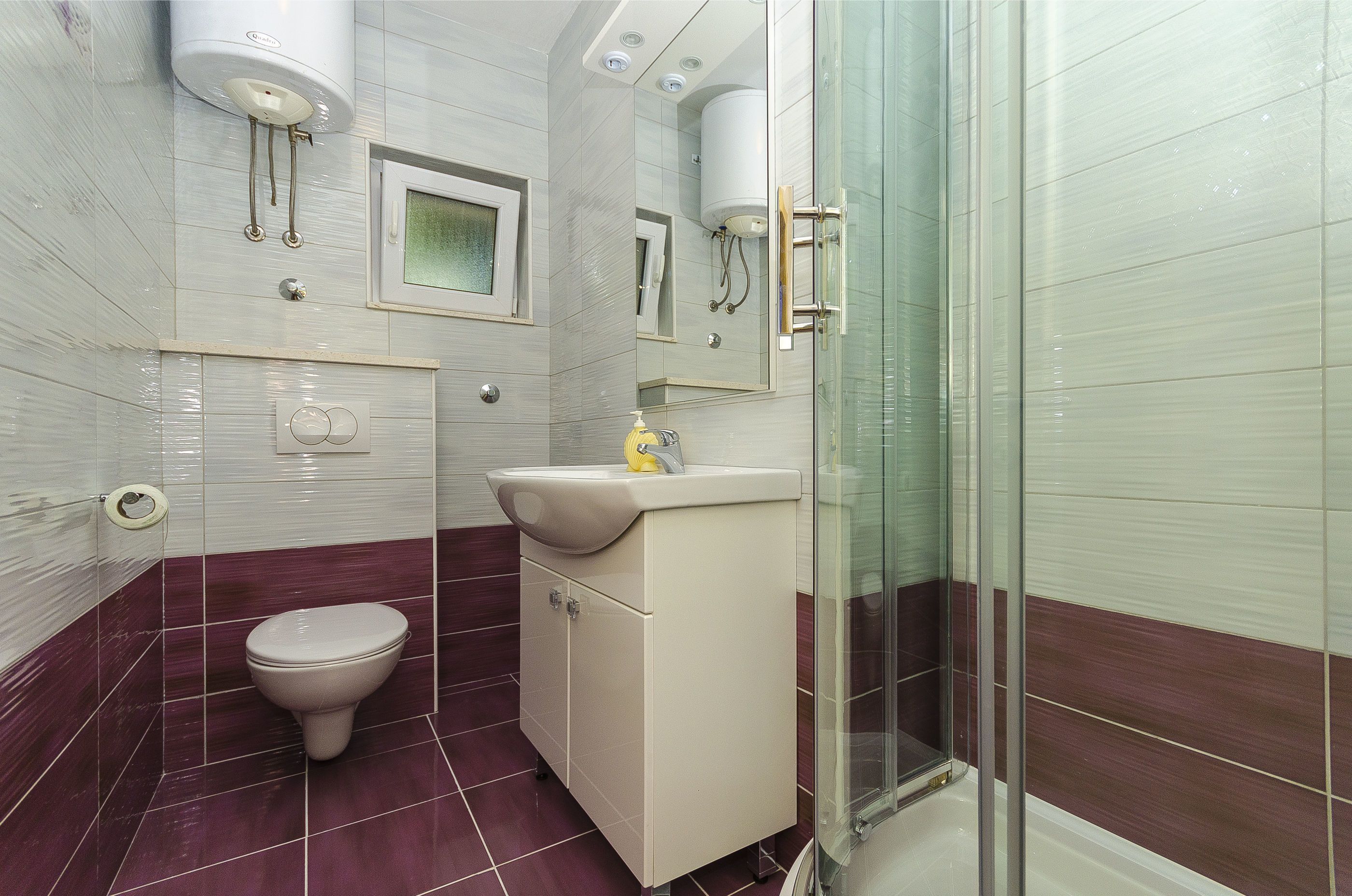 Une salle de bain comprenant des toilettes, un lavabo et un espace douche.