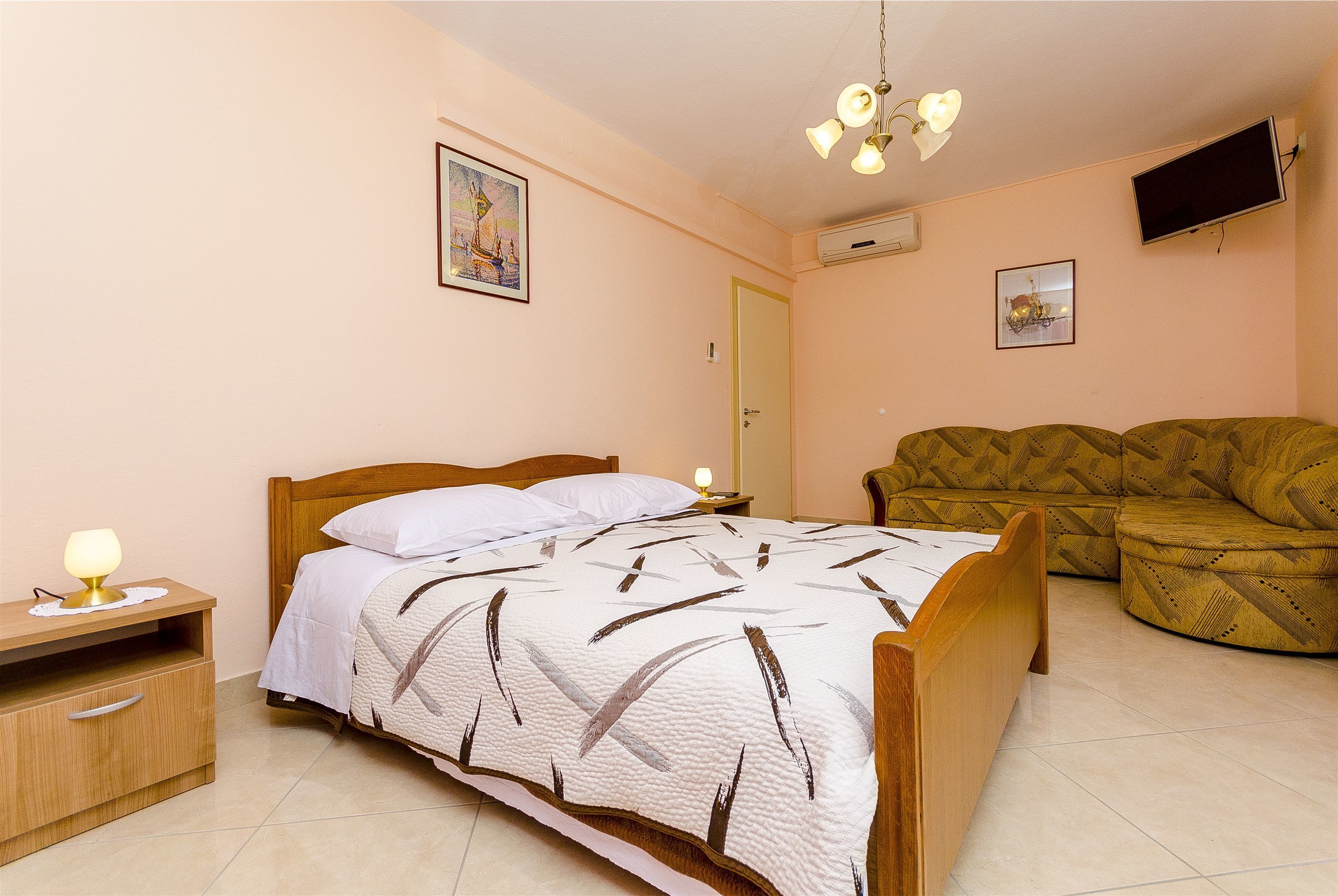 Une chambre à coucher avec un lit, une table de chevet, une lampe et un canapé.