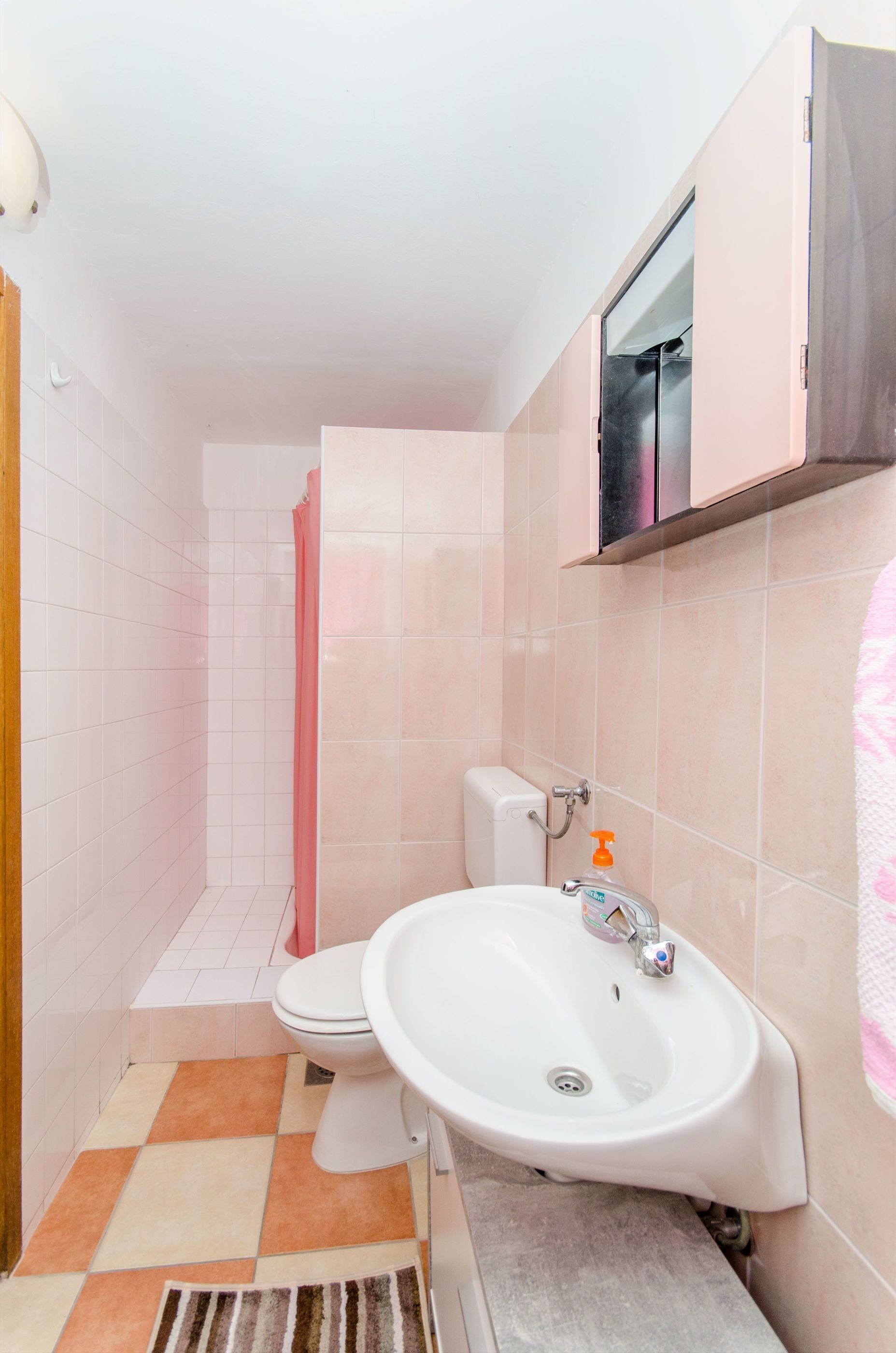 Un bagno con il water, lavandino e doccia.