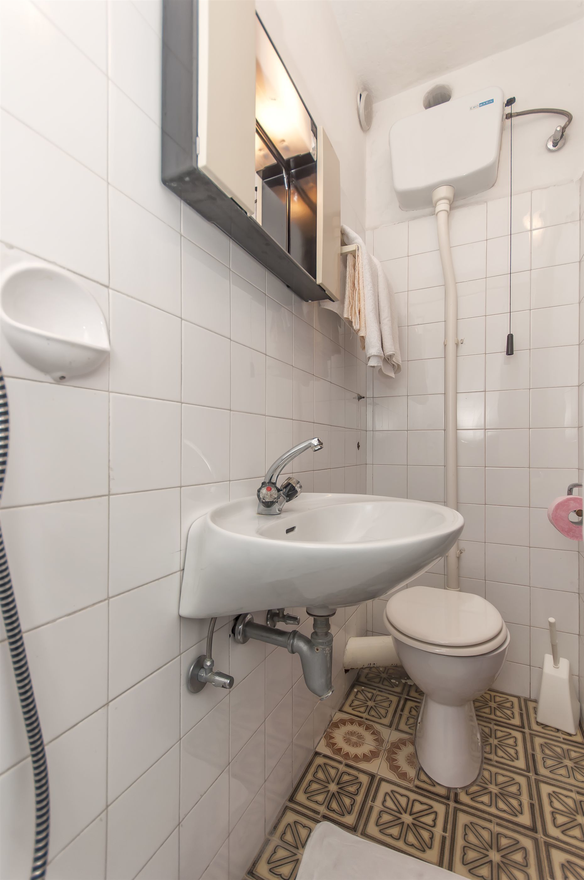 Een badkamer met een witte wastafel, toilet en douche.